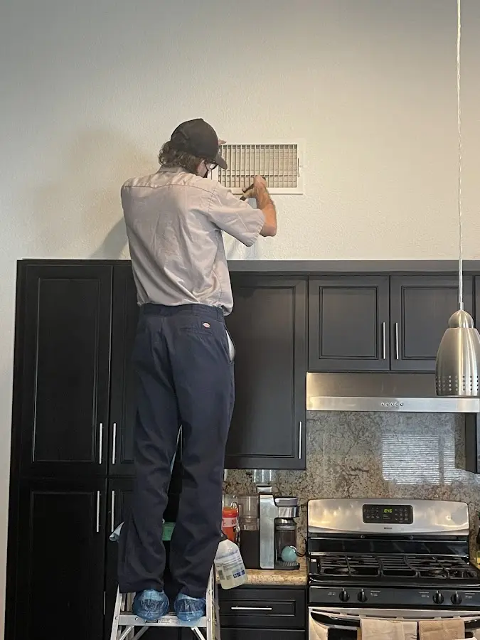 Technician inspecting an air vent during HVAC service in Hollidaysburg